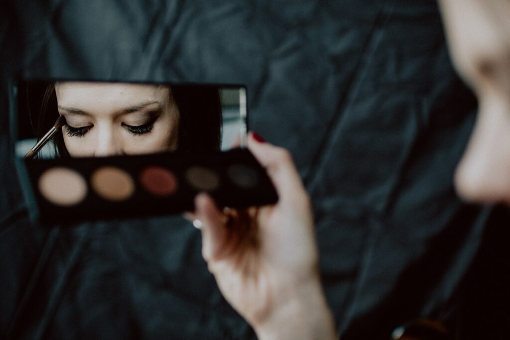 A woman putting on eye makeup for a TikTok tutorial.