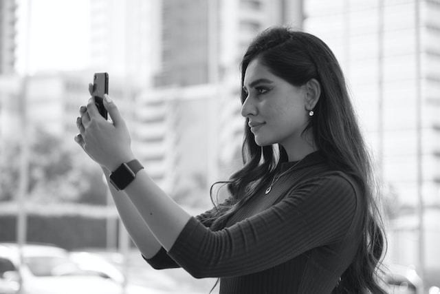 A woman taking a selfie for TikTok.