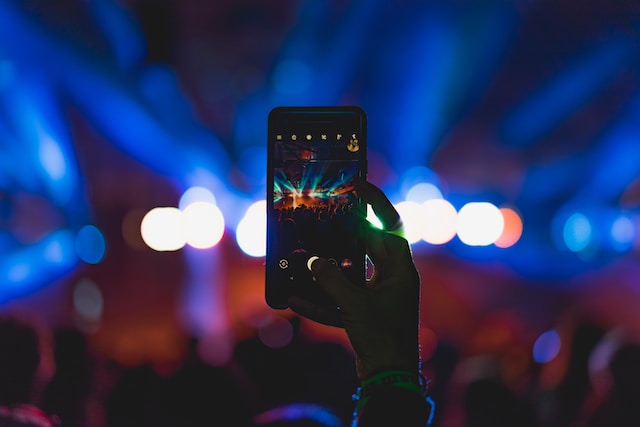 A person capturing a live performance using their phone.