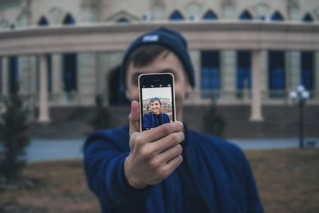 A person taking a video of himself using his phone.