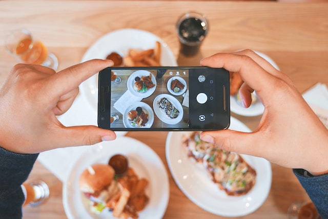 A person creating a video for a food review.