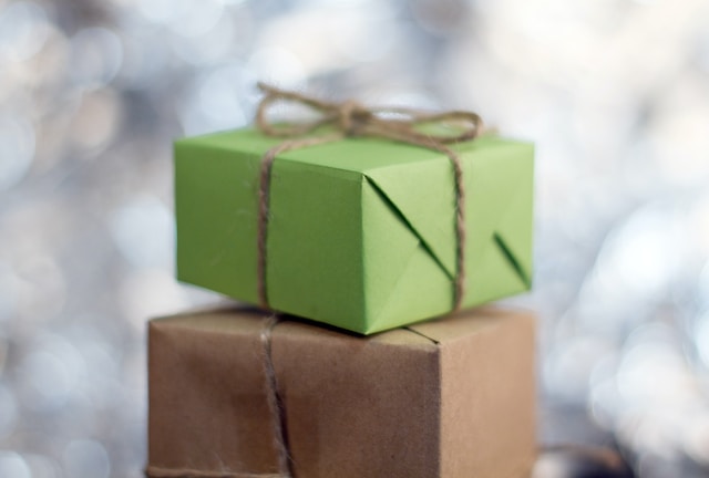 A stack of gifts wrapped in green and brown paper.