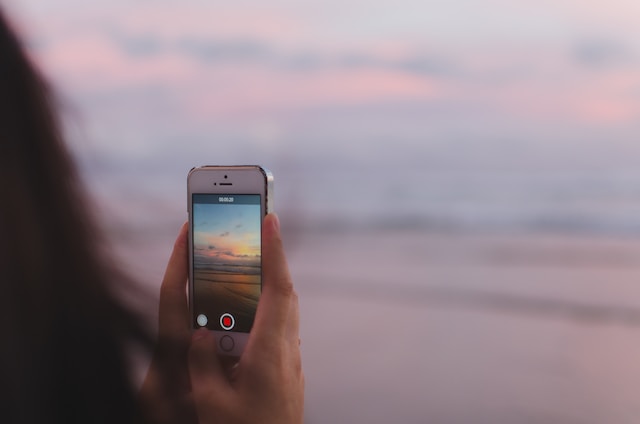 A person recording the sunset with their phone camera.