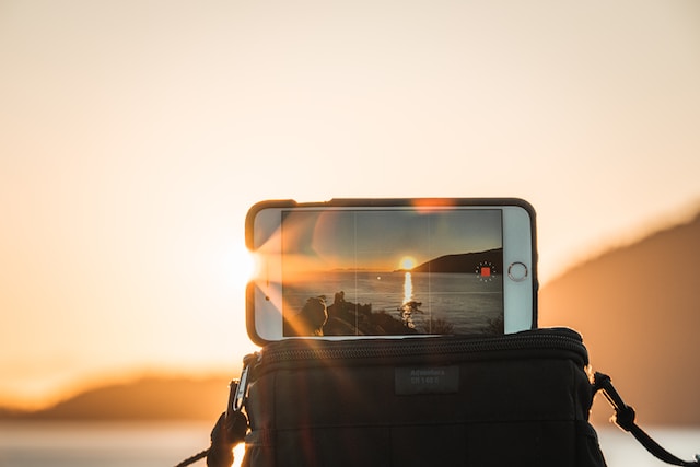 A person filming the sunset with their phone.