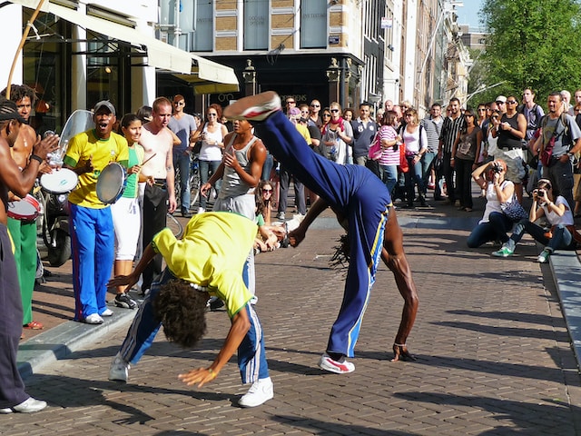 Street performing breakdancing in front of a big crowd.