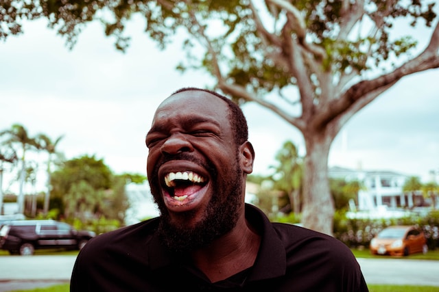 A man standing outside and laughing.
