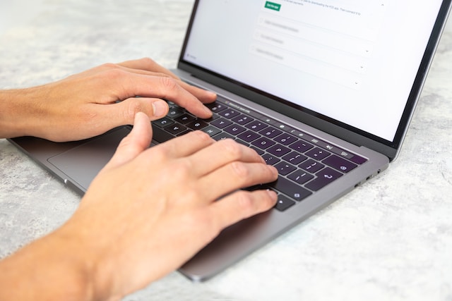 A person typing on their laptop.