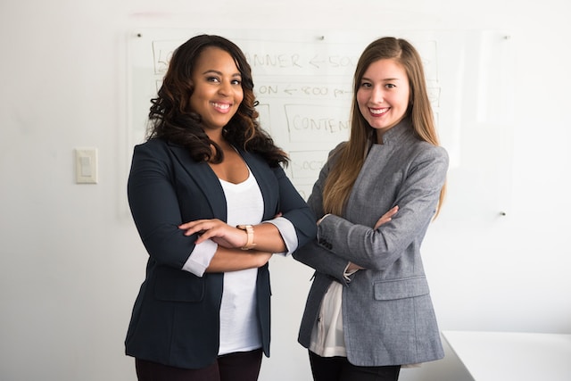 Two female professionals standing in front of a whiteboard.