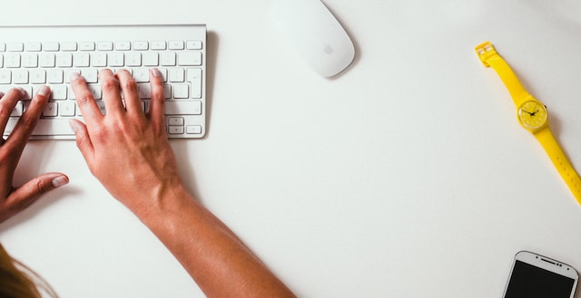 A person typing comments on a white keyboard.
