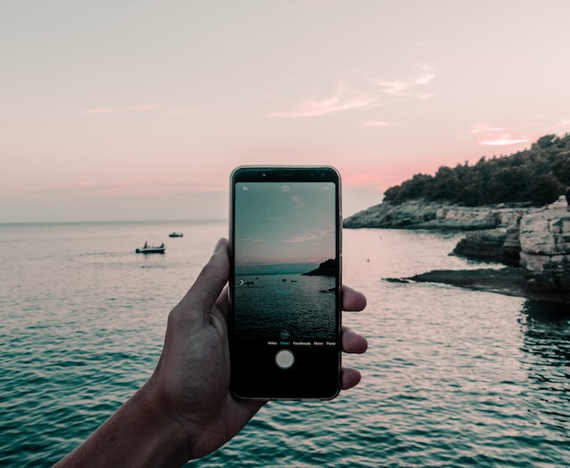 A person taking a video of the sea with their phone.