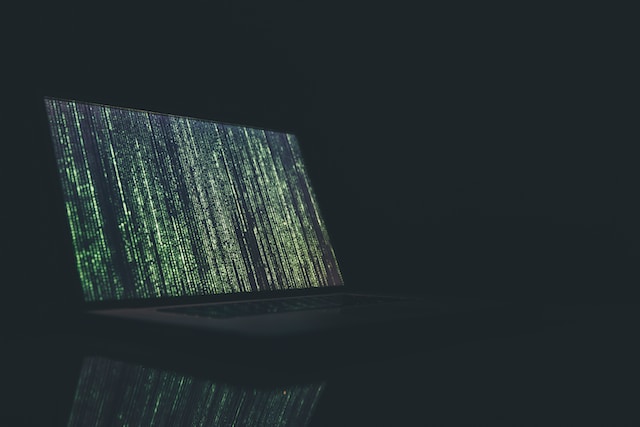A laptop screen displaying streaming computer code.