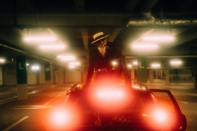 A model sitting on the roof of a car with the headlights on.