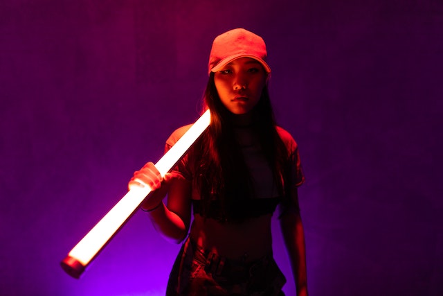 A woman in a red cap holding a white fluorescent.