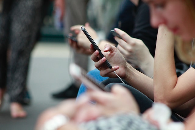 A group of people watching videos on their smartphones.