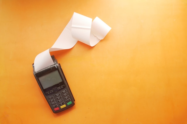 A credit card reader dispensing a receipt.