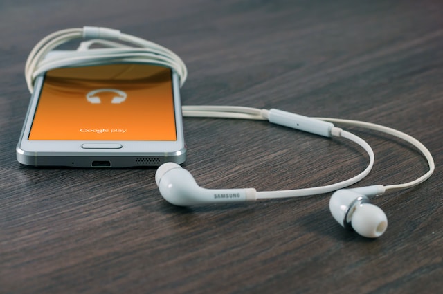 A white phones with white earphones attached to it