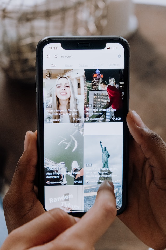 Someone holding their phone and going through TikTok videos.