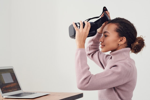 A girl wearing VR goggles and gaming.