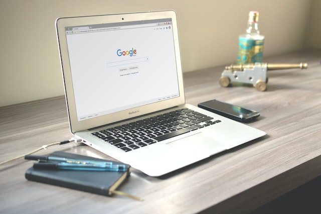 The Google search page is displayed on a laptop screen.