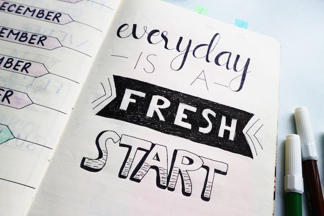 A message in a notebook reads, “Every day is a fresh start.”