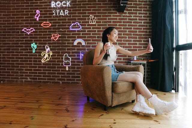 A TikTok creator sits on a chair and makes a video for her followers.