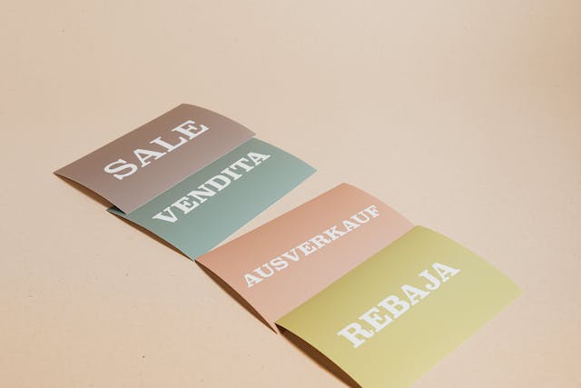 Signs display the word “SALE” in four different languages.