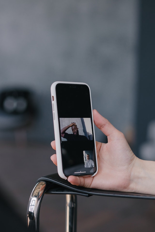 A hand holding a smartphone recording a video for TikTok.