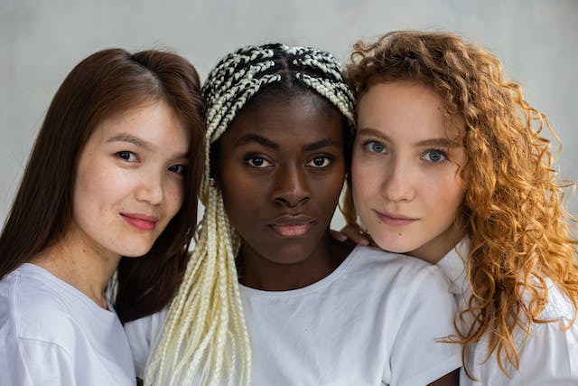 A photo of three women from different cultural backgrounds and languages.