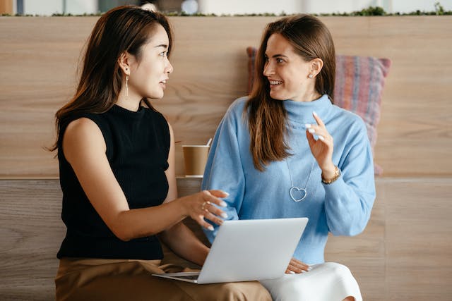 A photo of two female professionals engaged in a lively conversation.