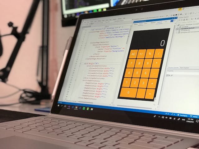 A laptop screen displays a calculator app.
