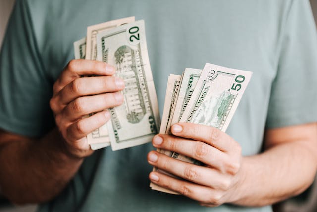 A person counts dollar bills.