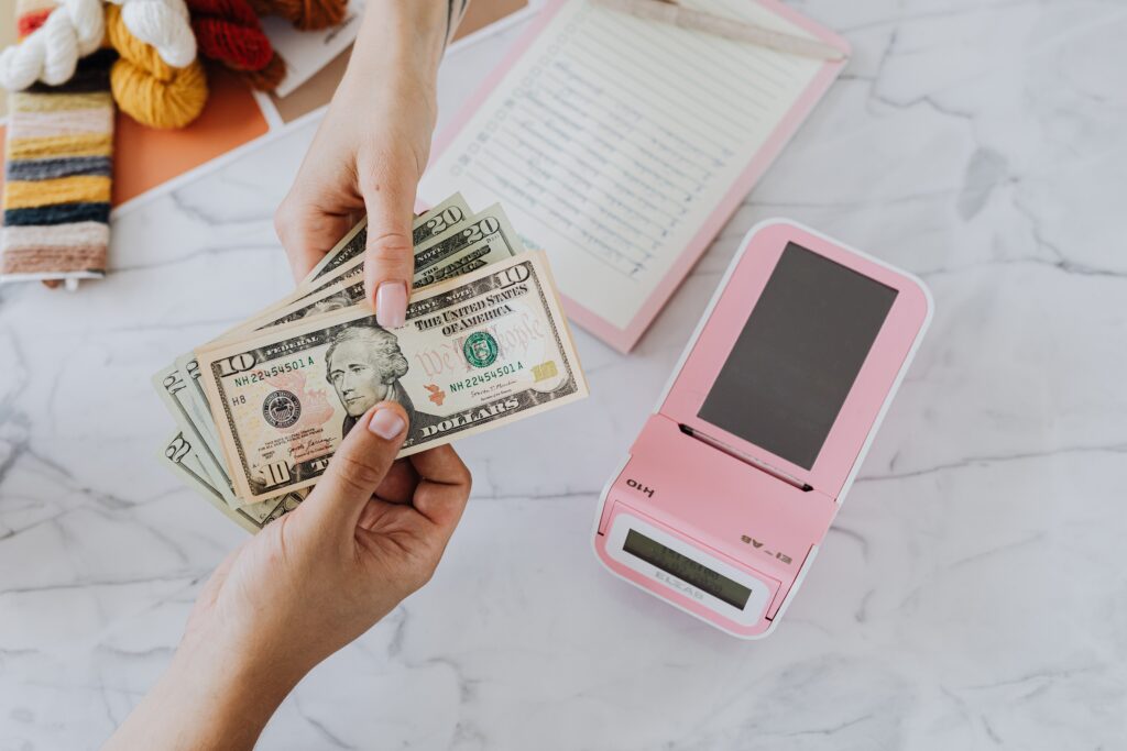 One person hands out dollar bills to another to make a payment.