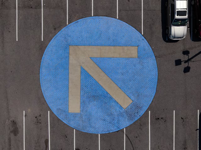 A photo of a gray arrow on a blue circle.
