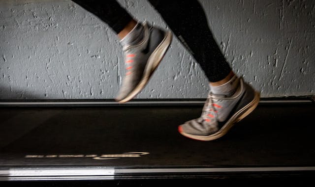 A close-up shot of feet running on a treadmill.