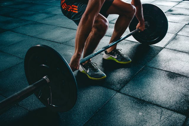 A photo of a man about to lift a barbell.