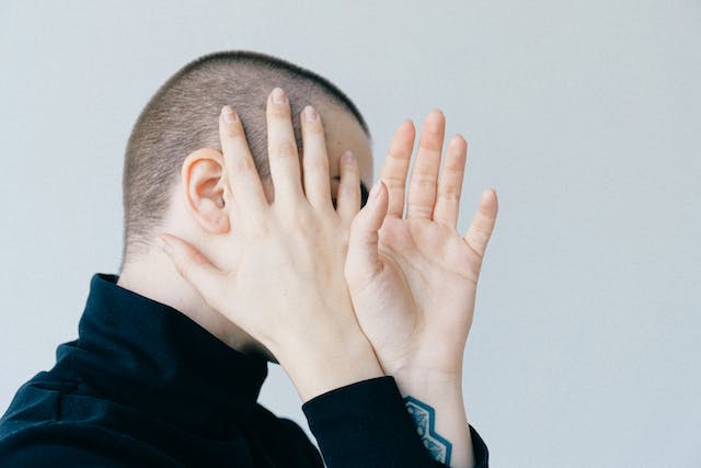 A person covers their face with their hands.