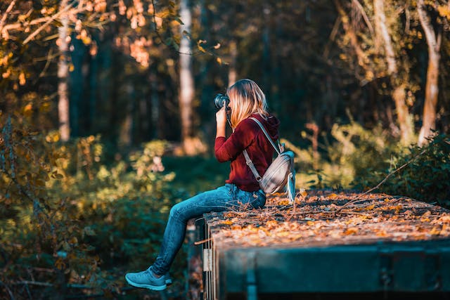 A woman takes nature photos with her DSLR camera.