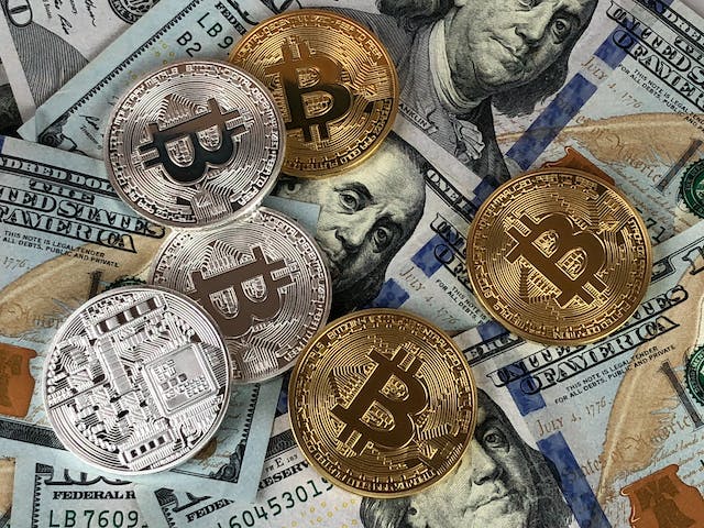 An image of silver and gold coins on top of dollar bills.