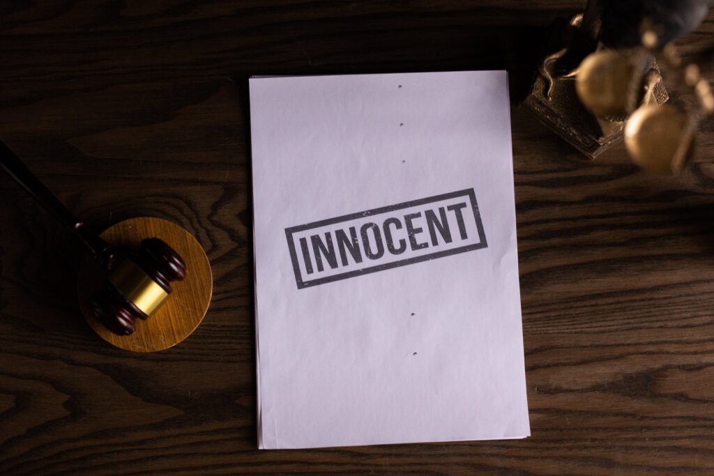 A gavel and piece of paper with the word “INNOCENT” printed on it.