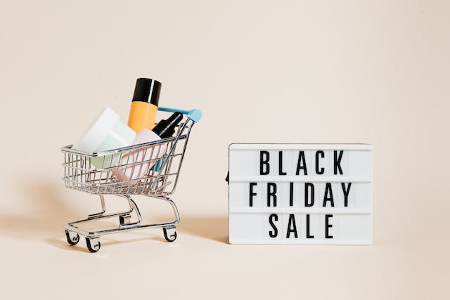 A photo of a Black Friday Sale sign beside a shopping cart.