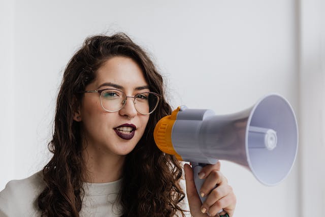 A woman speaks into a megaphone.