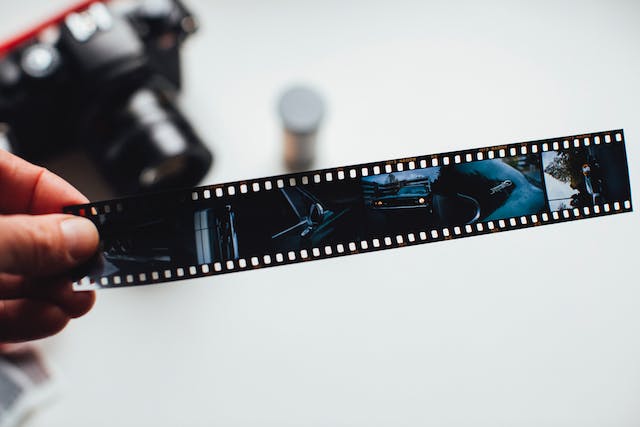 A person studies a film negative.