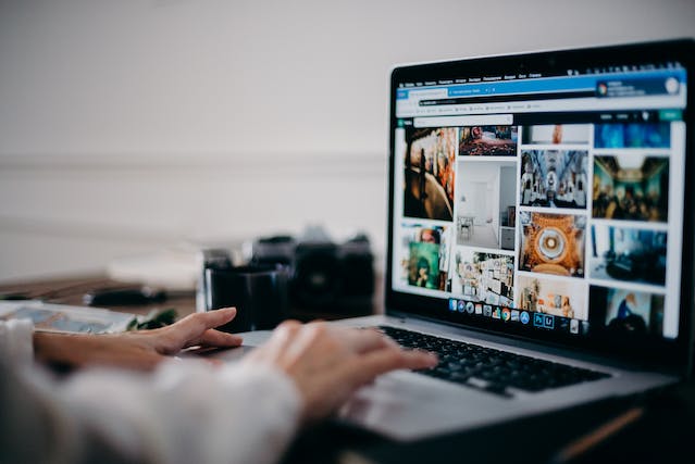 A person looks through online photos on their laptop.