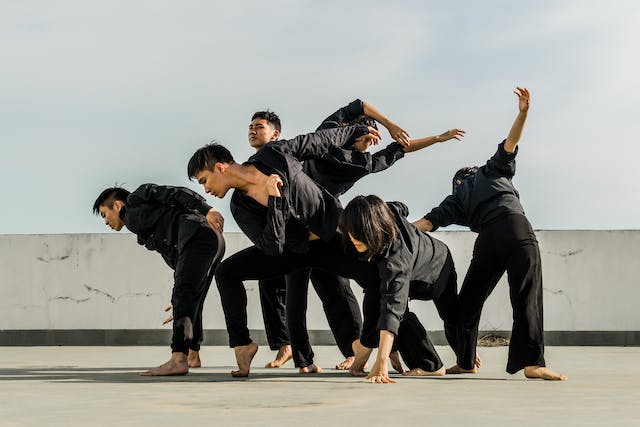 A group of people practices their dance on a rooftop.