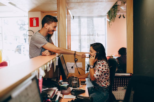 A man touches a woman’s nose with his finger.
