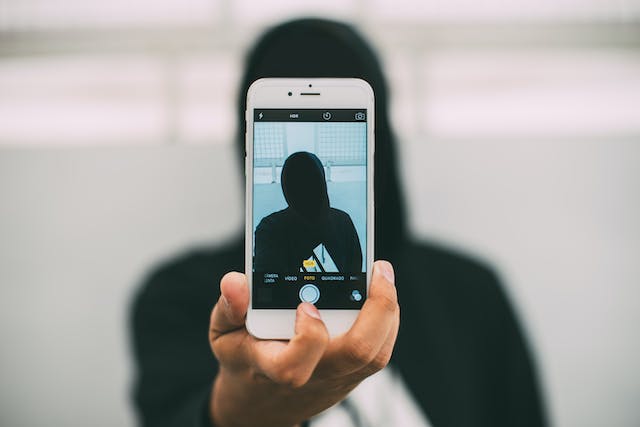 A person takes a selfie with their phone.