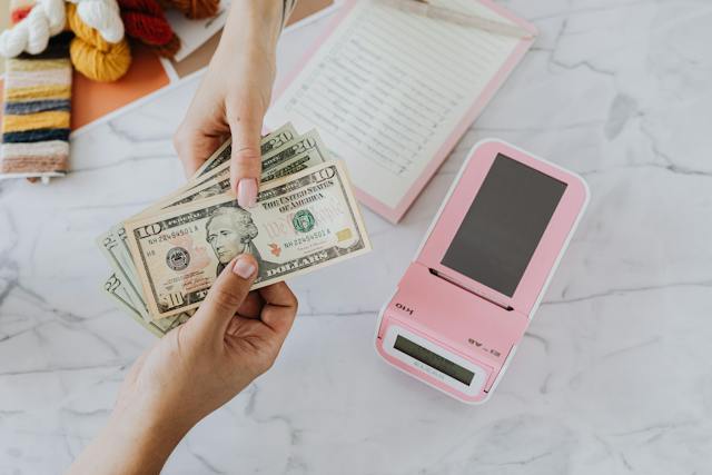 A person handing cash to another person.
