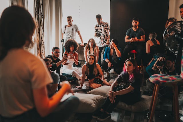 A group of people is gathered around a speaker in a studio.