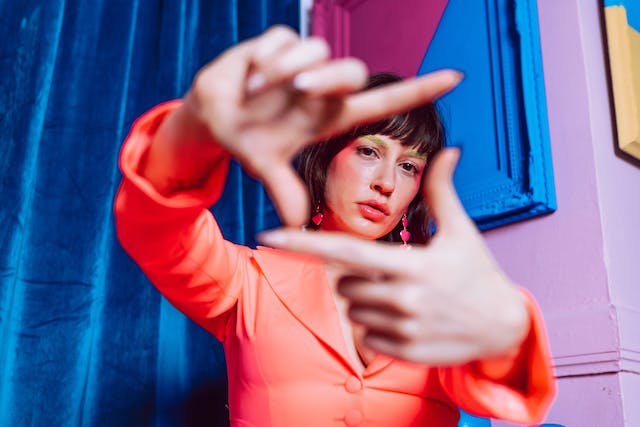 An image of a woman framing her face with her fingers.