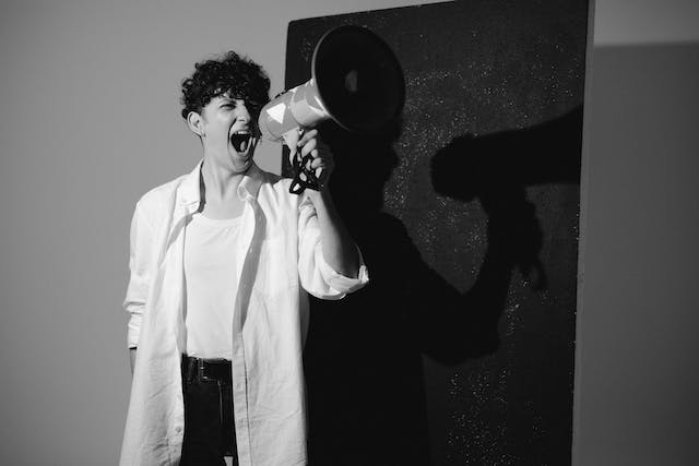 A person is passionately shouting into a megaphone.